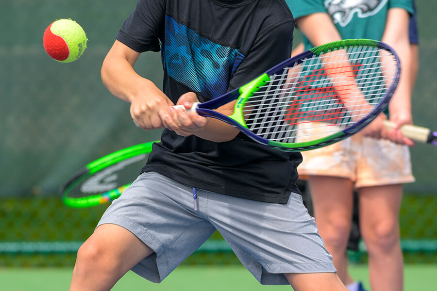 youth tennis player about to return volley