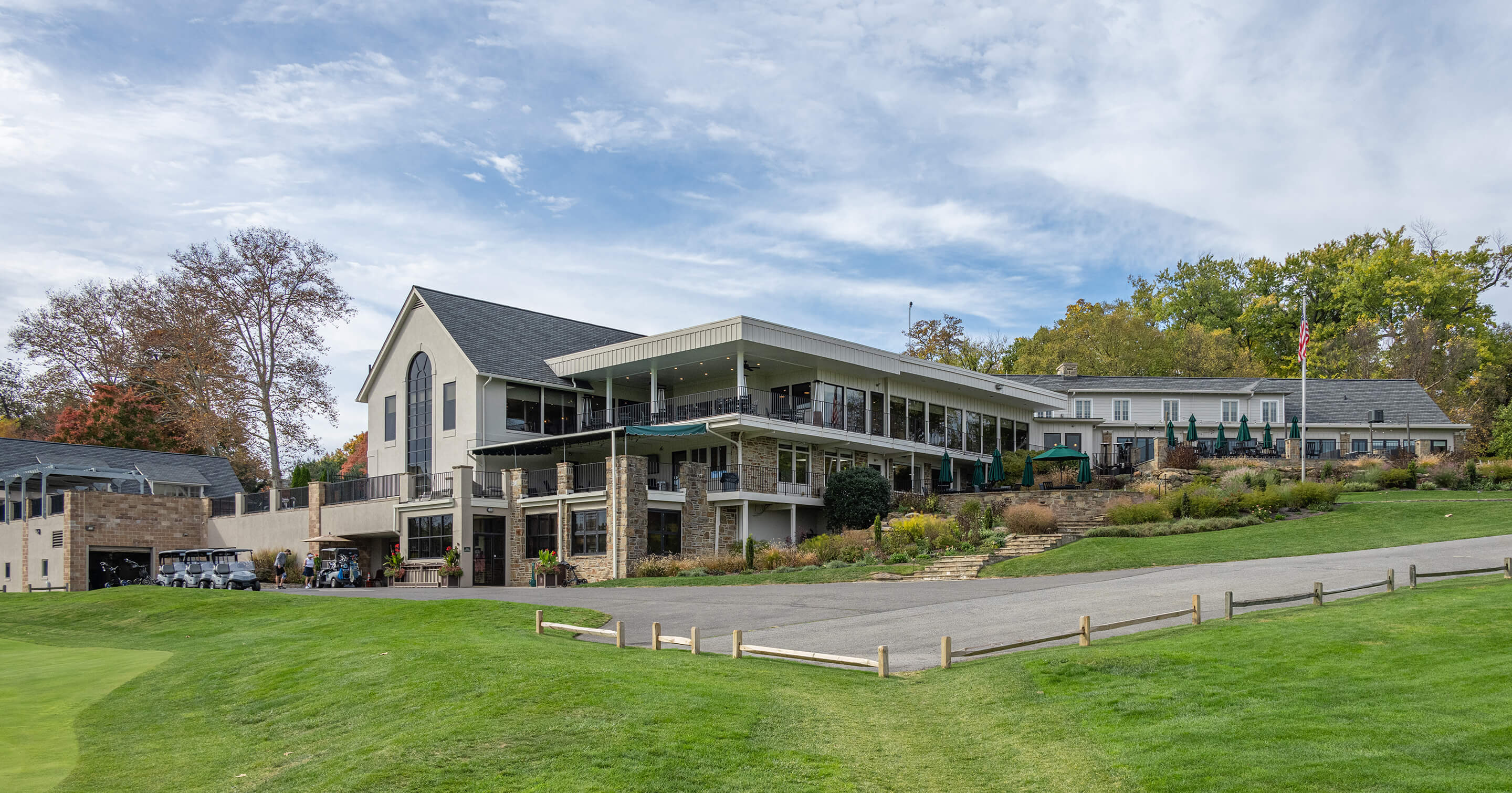 View of clubhouse exterior with decks, landscaping, flagpole